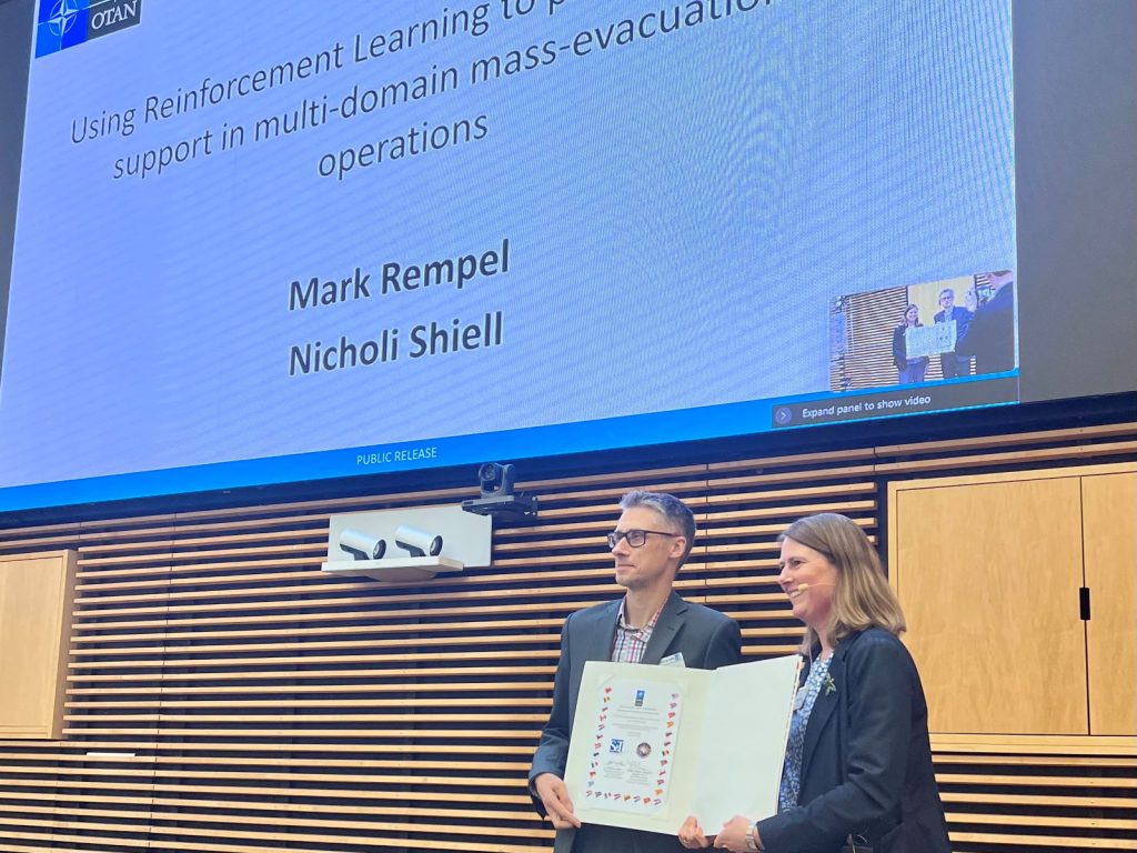 Mr. Mark Rempel receives Best Paper Award from Ms. Sue Collins, HQ SACT, Conference Co-Chair